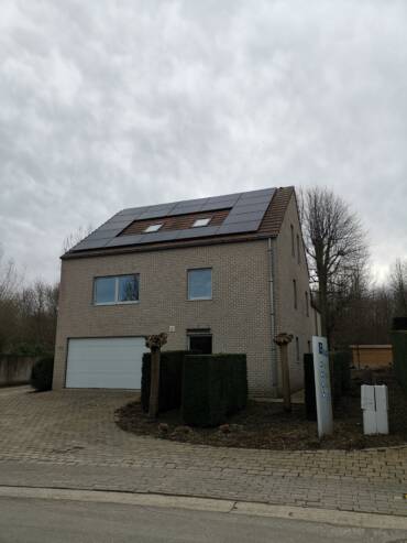 Een huis met zonnepanelen op het dak.