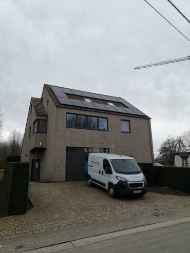 Une maison avec une camionnette garée devant.